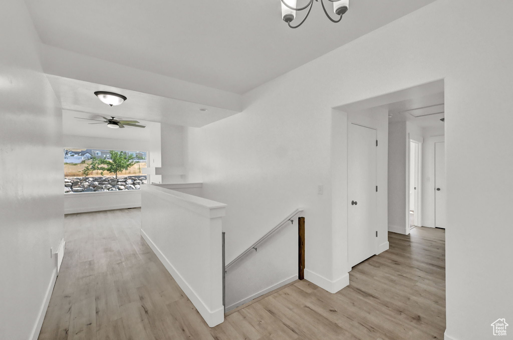 Hall featuring light hardwood / wood-style floors and a chandelier