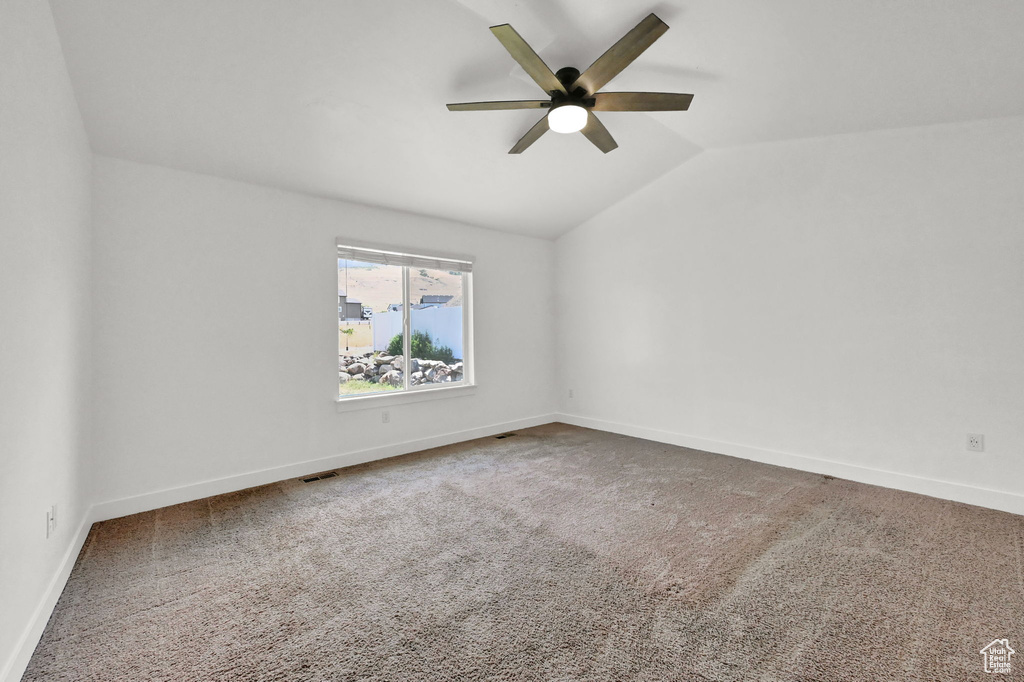 Carpeted spare room with lofted ceiling and ceiling fan