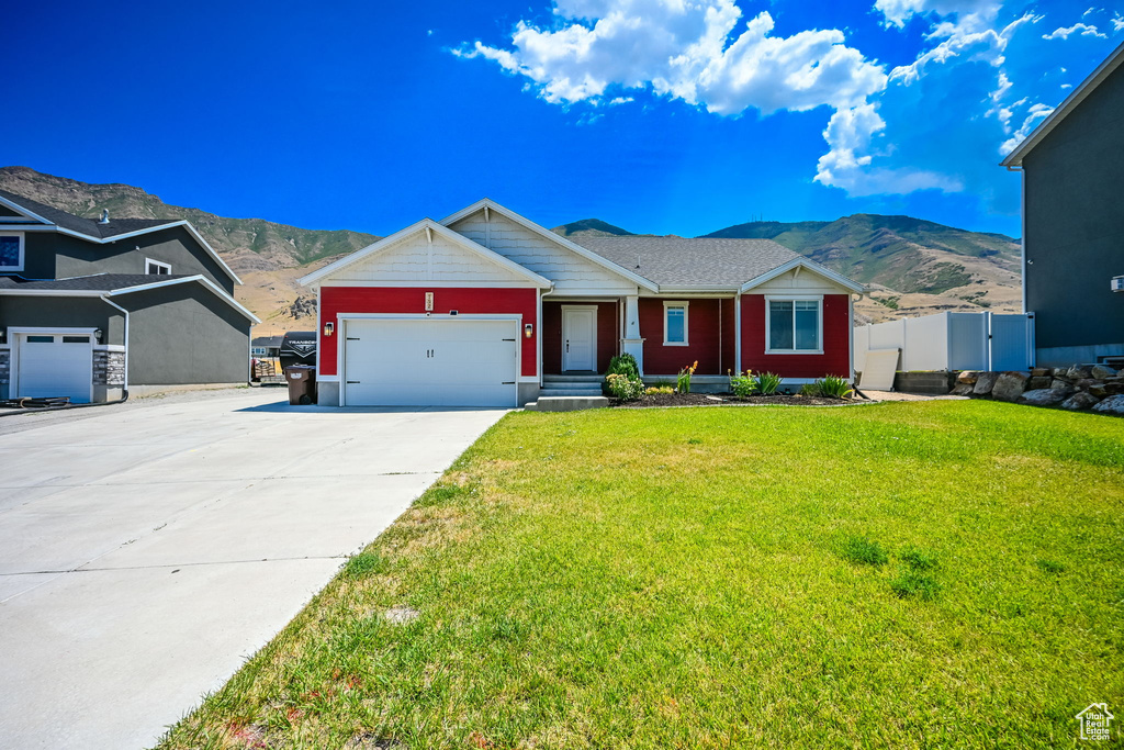 View of front of property with a mountain view and a front yard