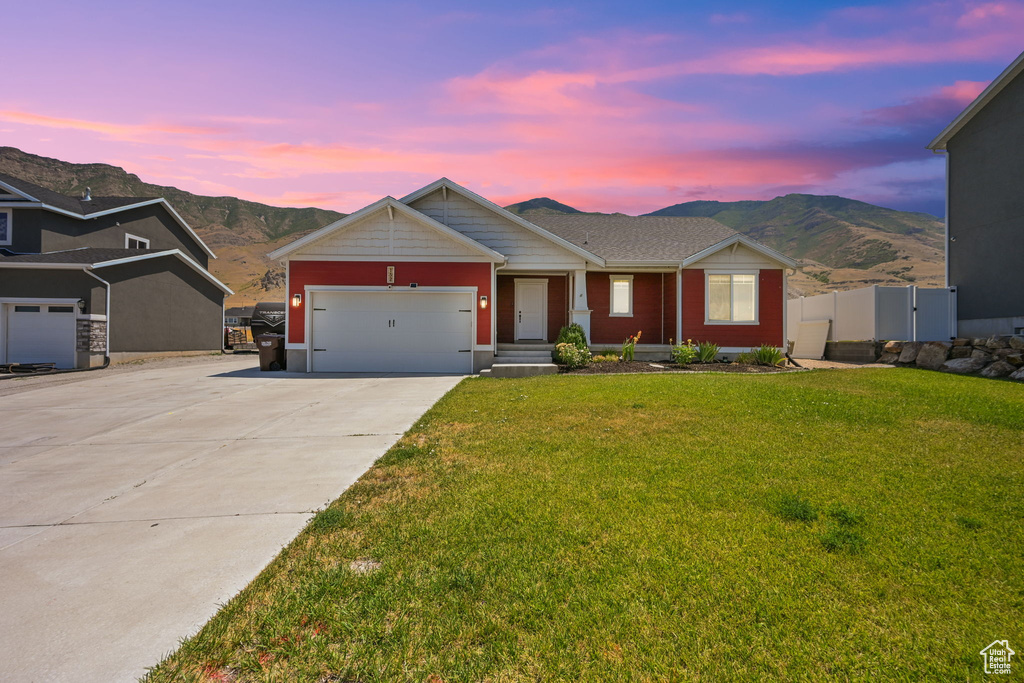 View of front of house with a yard and a mountain view