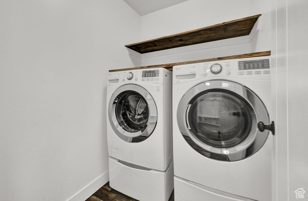 Washroom featuring dark wood-type flooring and washer and clothes dryer