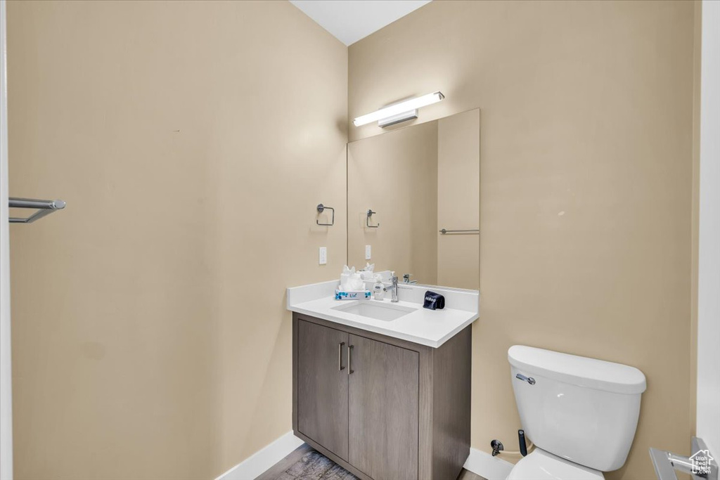 Bathroom featuring hardwood / wood-style floors, vanity, and toilet