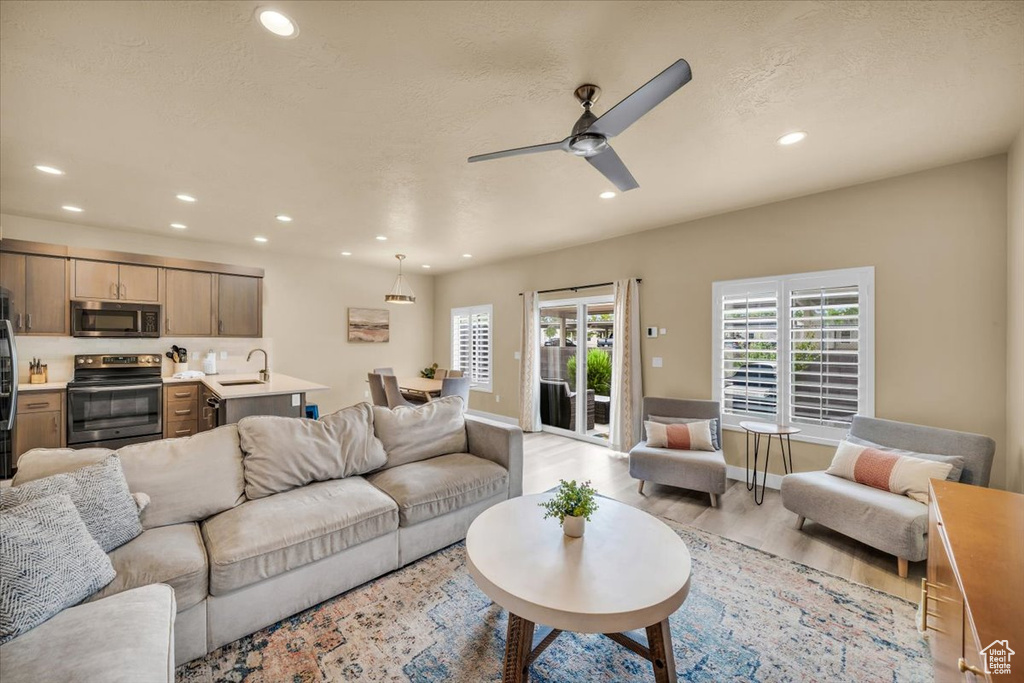 Living room featuring light hardwood / wood-style floors, sink, and ceiling fan