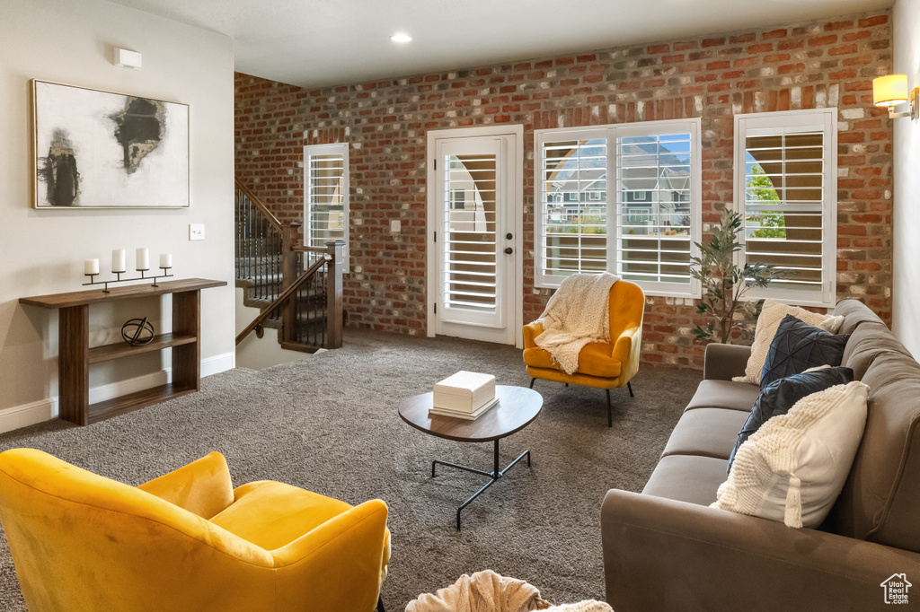 Living room featuring brick wall and carpet