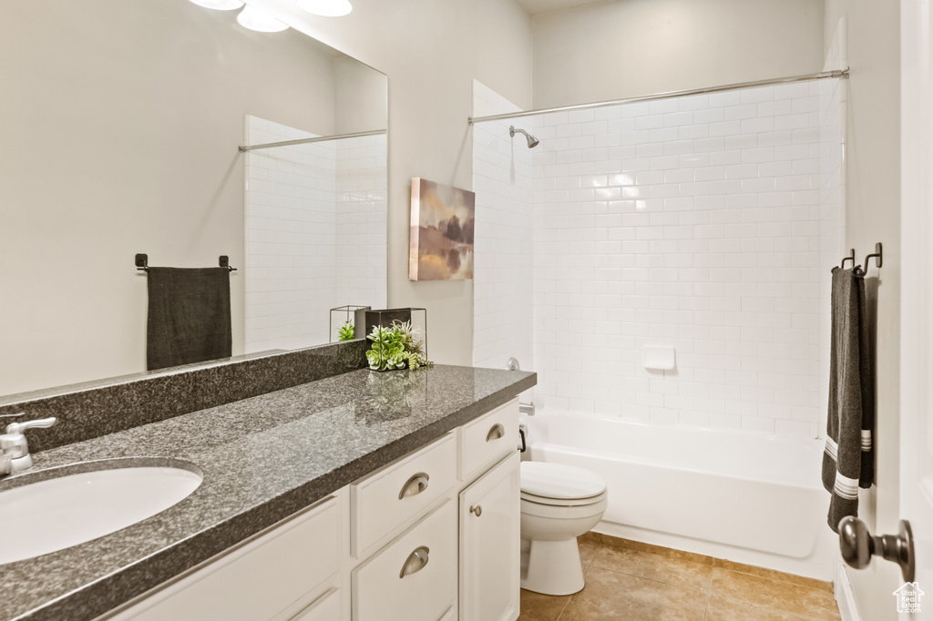 Full bathroom featuring tile patterned flooring, tiled shower / bath combo, toilet, and vanity