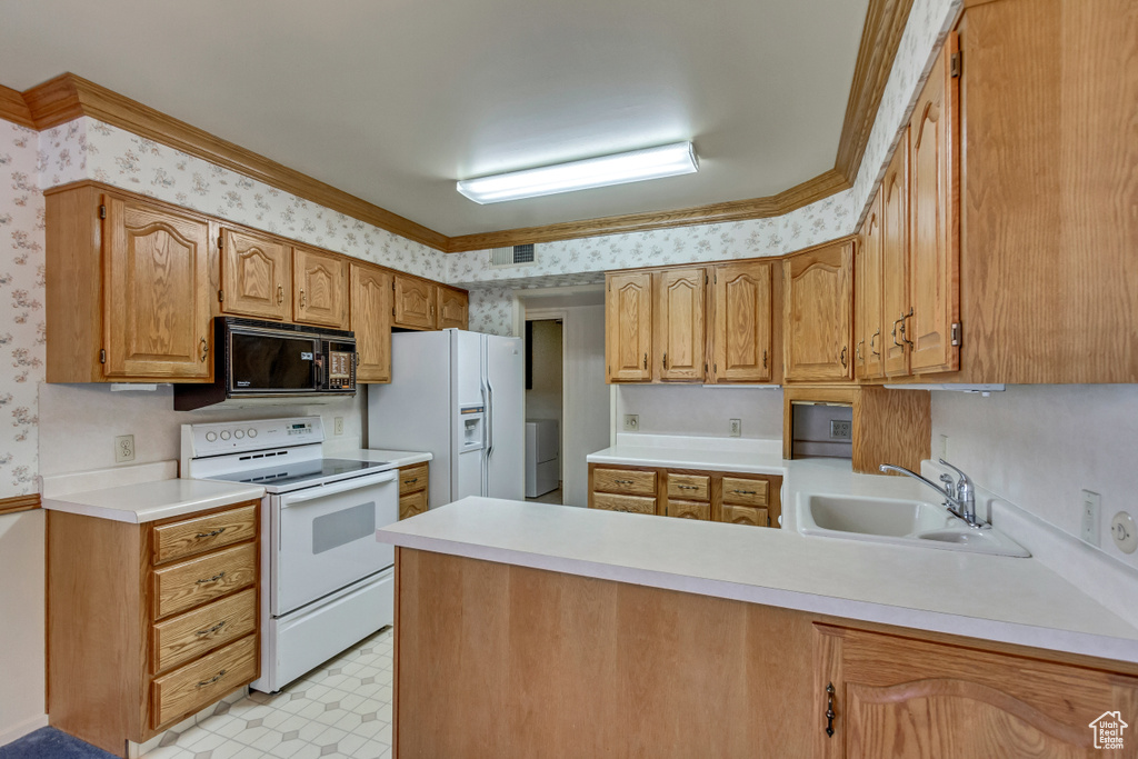 Kitchen featuring white appliances, sink, kitchen peninsula, crown molding, and light tile patterned flooring