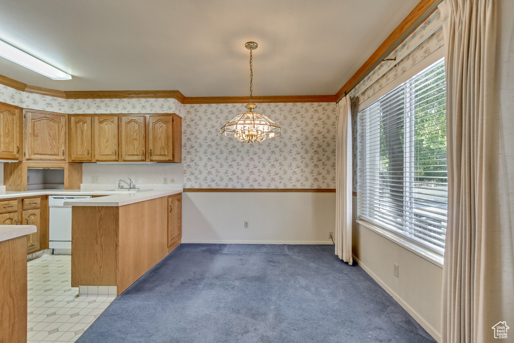 Kitchen with decorative light fixtures, light tile patterned flooring, crown molding, dishwasher, and kitchen peninsula