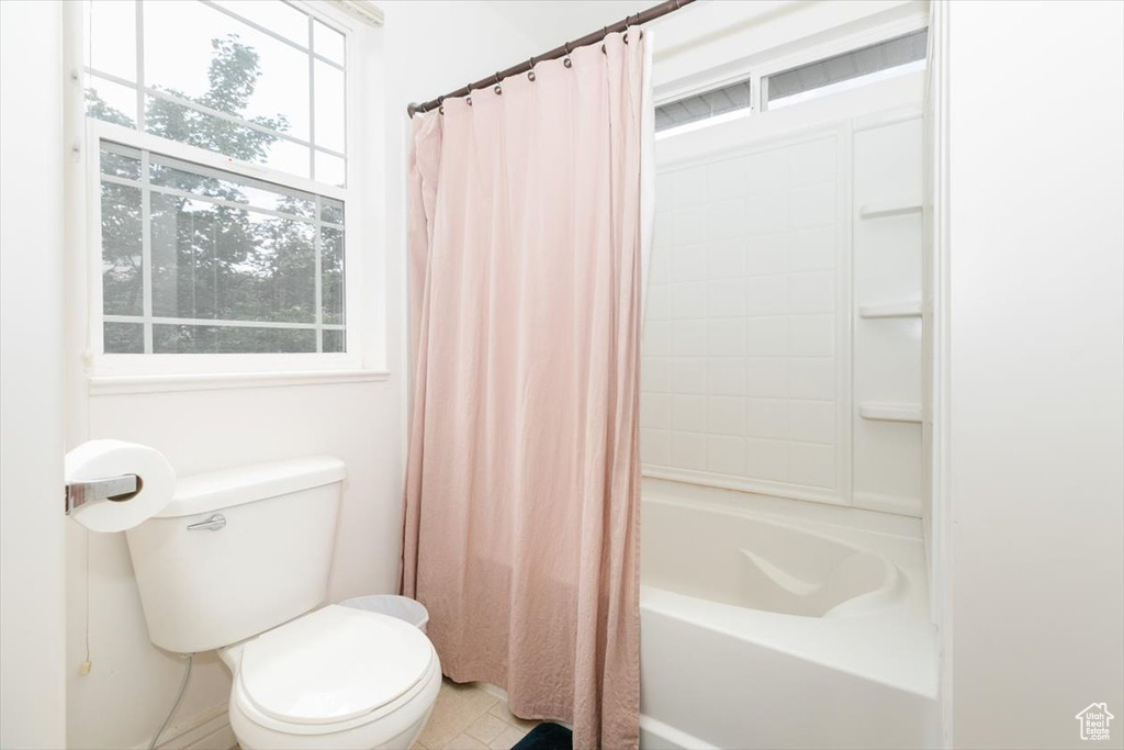 Bathroom with toilet, tile patterned floors, and shower / bath combo