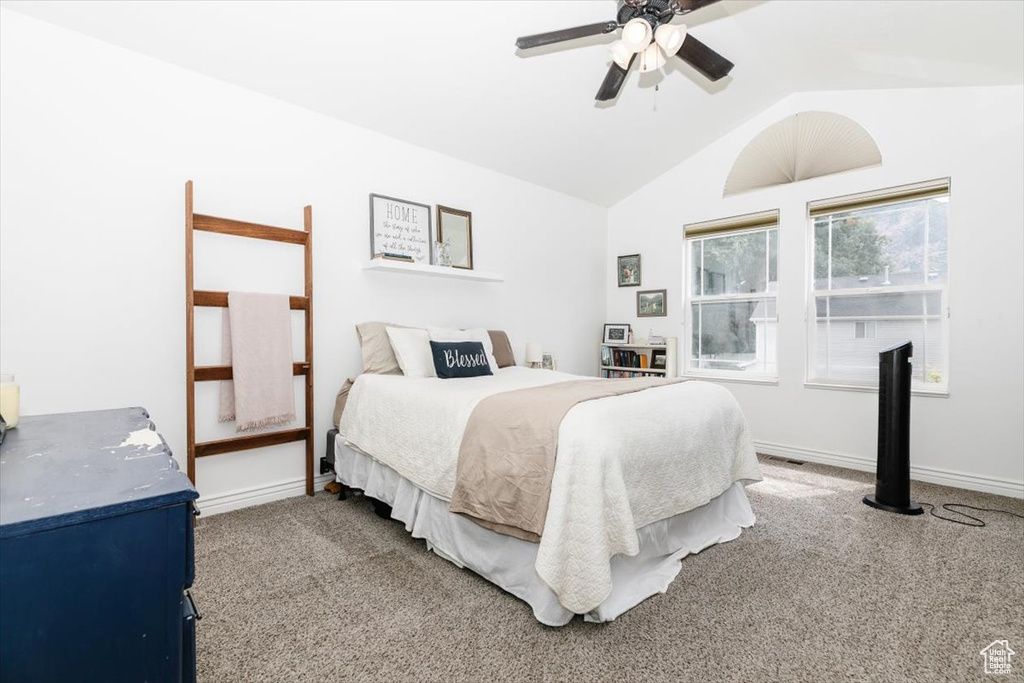 Carpeted bedroom with ceiling fan and vaulted ceiling