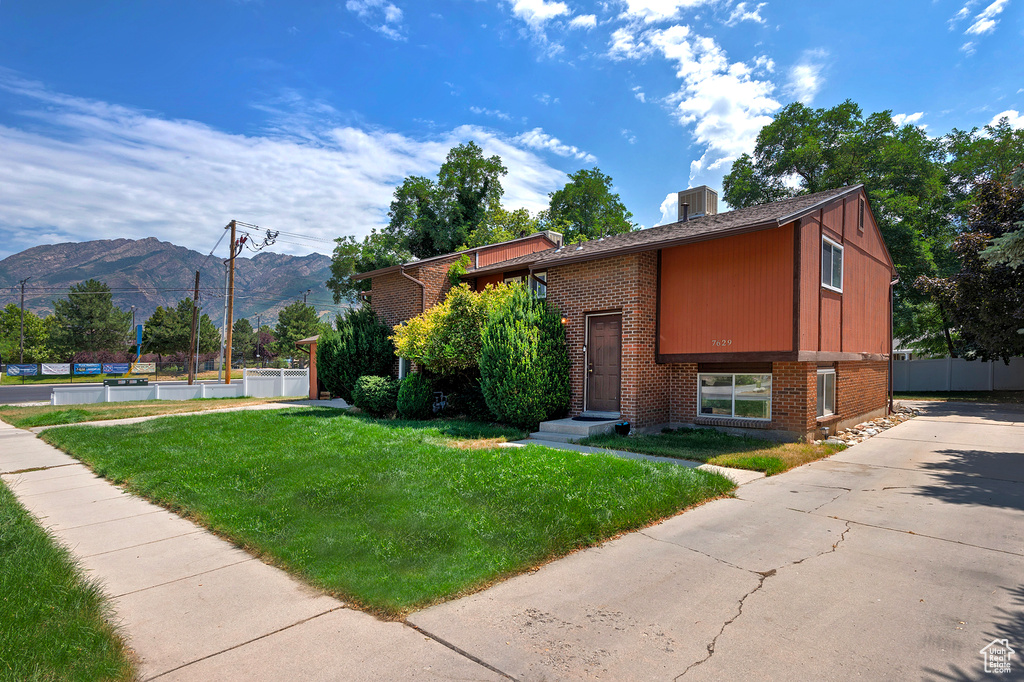 View of front facade with a mountain view and a front yard