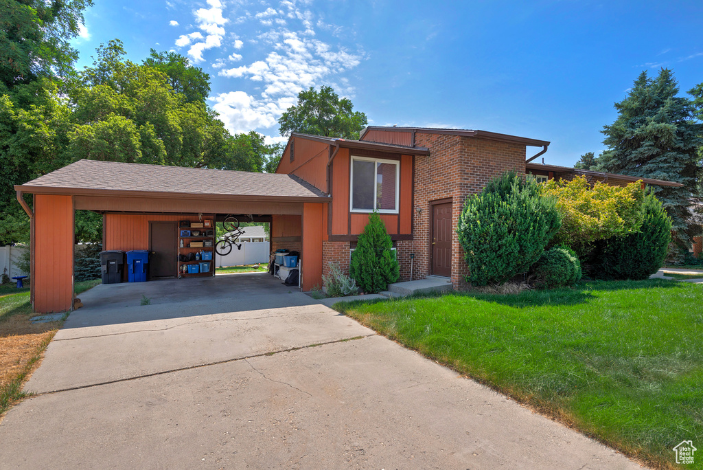 View of front of house featuring a carport and a front yard