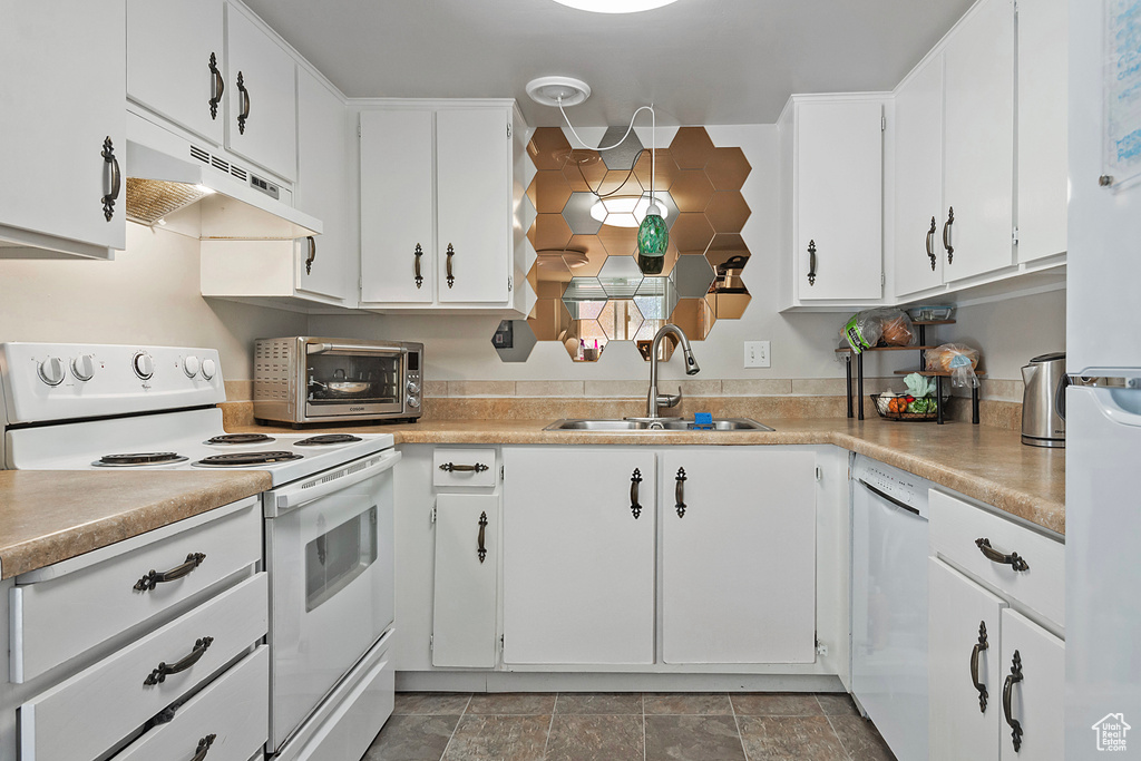 Kitchen with light tile patterned flooring, sink, white appliances, and white cabinets