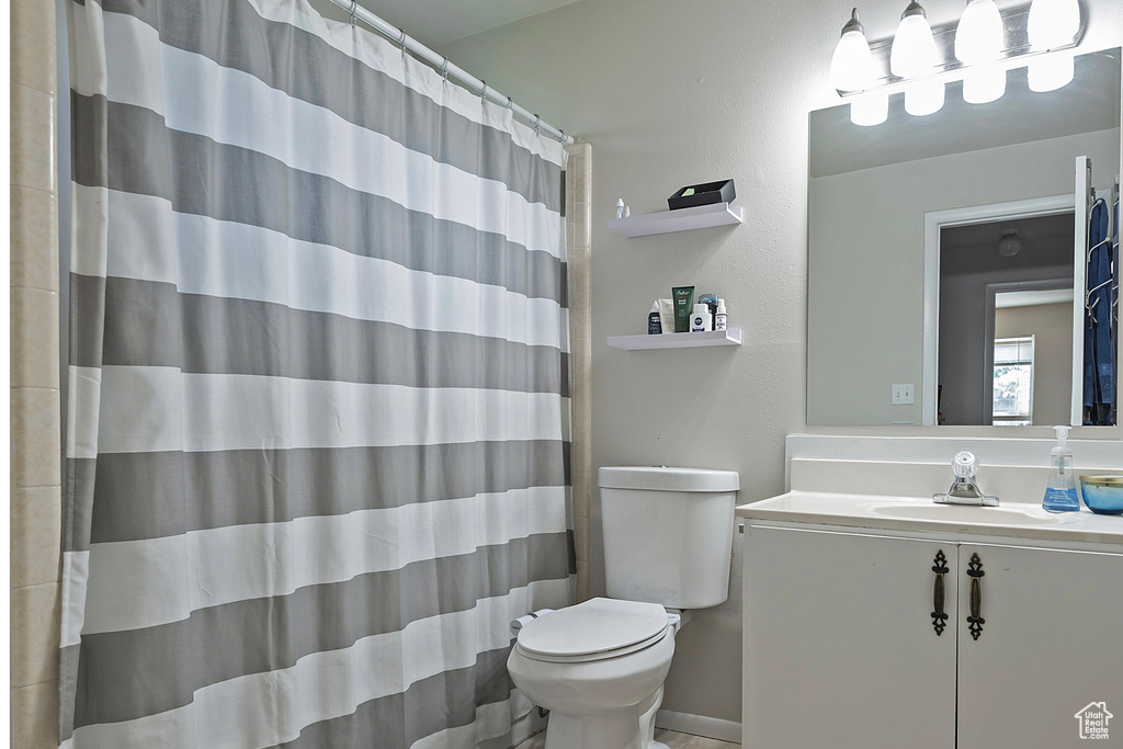 Bathroom featuring tile patterned floors, toilet, and vanity