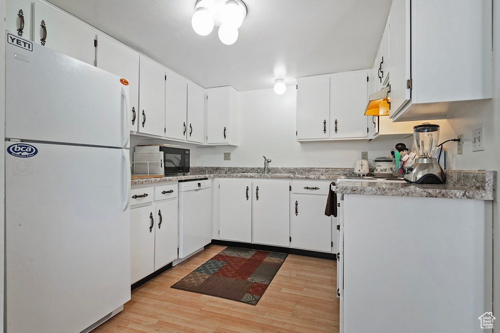 Kitchen with white cabinetry, exhaust hood, white appliances, and light wood-type flooring