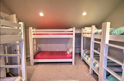 Carpeted bedroom featuring vaulted ceiling