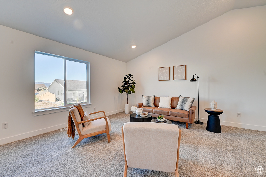 Carpeted living room with lofted ceiling