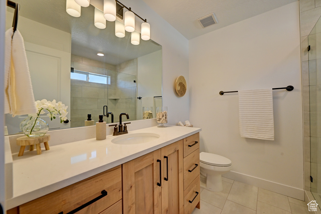 Bathroom featuring vanity, an enclosed shower, tile patterned flooring, and toilet