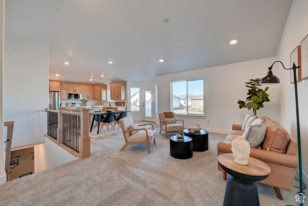 Carpeted living room with vaulted ceiling