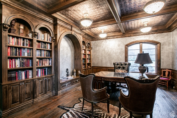 Home office featuring built in shelves, dark hardwood / wood-style flooring, ornamental molding, beam ceiling, and coffered ceiling