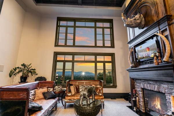 Living area with carpet, a brick fireplace, and a high ceiling