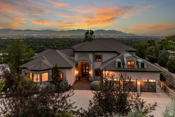 French country style house with a garage and a mountain view