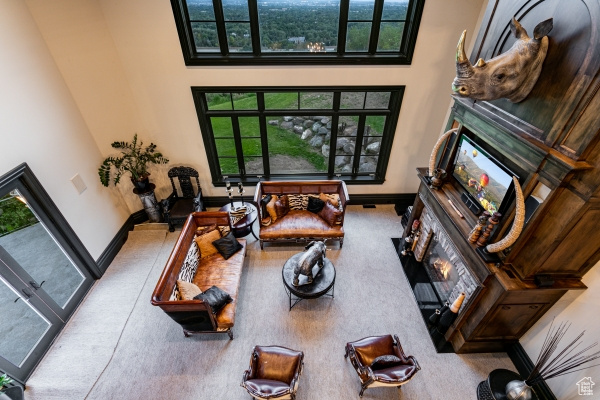 Living room featuring carpet flooring and a towering ceiling