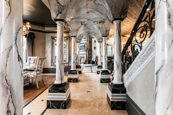 Interior space featuring crown molding, wood ceiling, and decorative columns