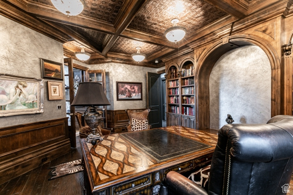 Home office featuring built in features, beamed ceiling, wood-type flooring, ornamental molding, and coffered ceiling