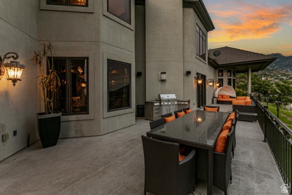 Patio terrace at dusk with area for grilling and a grill