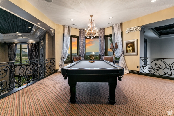 Rec room with a tray ceiling, a notable chandelier, carpet flooring, and billiards