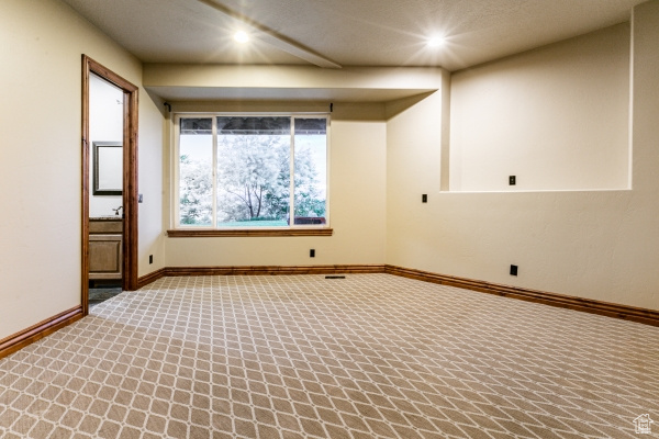 Spare room featuring carpet and a textured ceiling