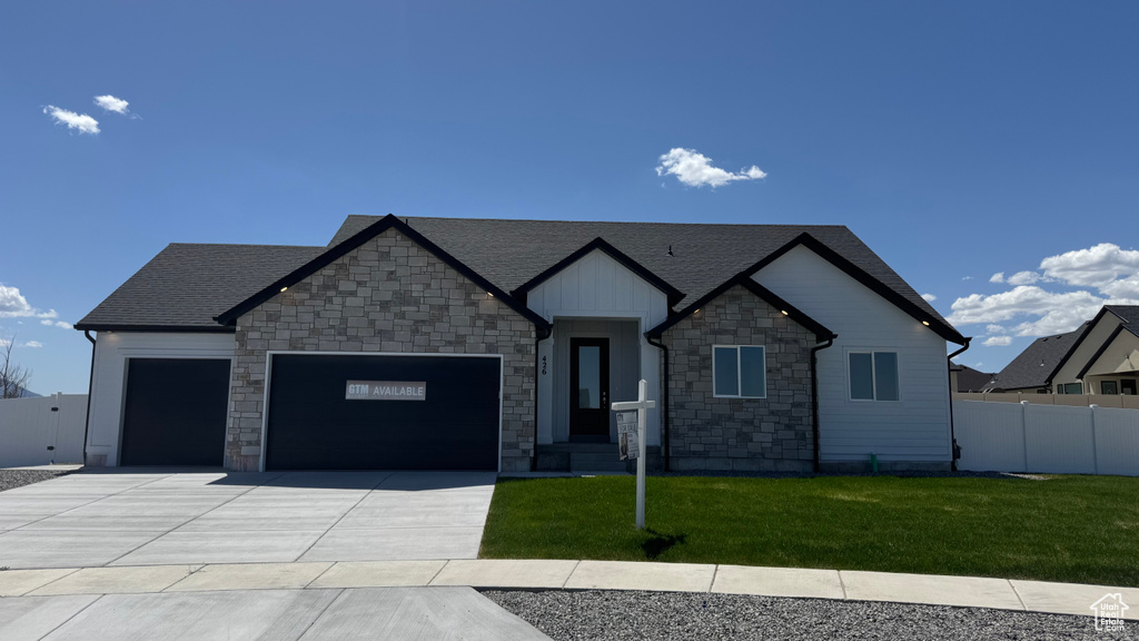 Craftsman-style house with an attached garage, stone siding, concrete driveway, and roof with shingles