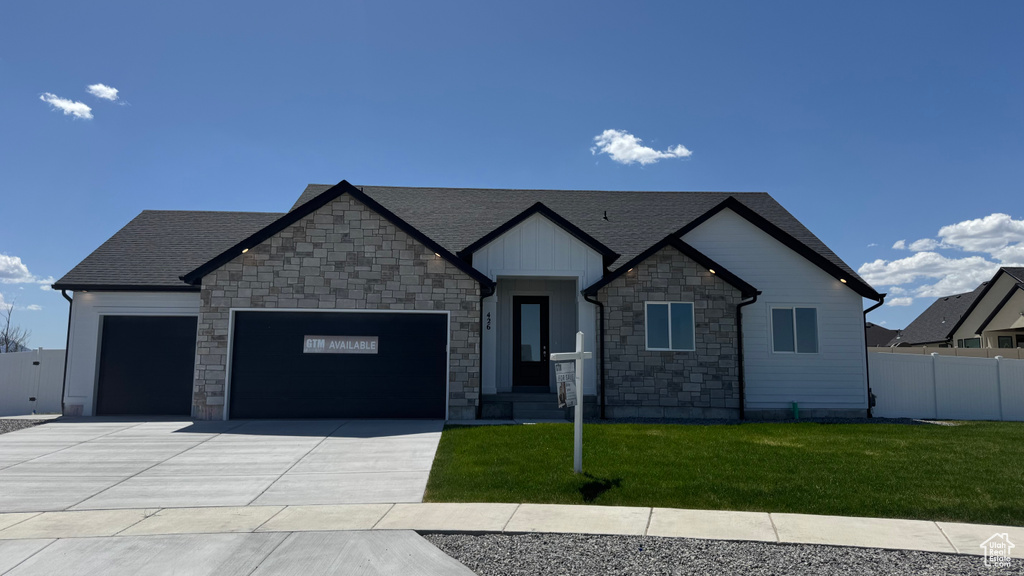 Craftsman-style home featuring stone siding, an attached garage, concrete driveway, and roof with shingles