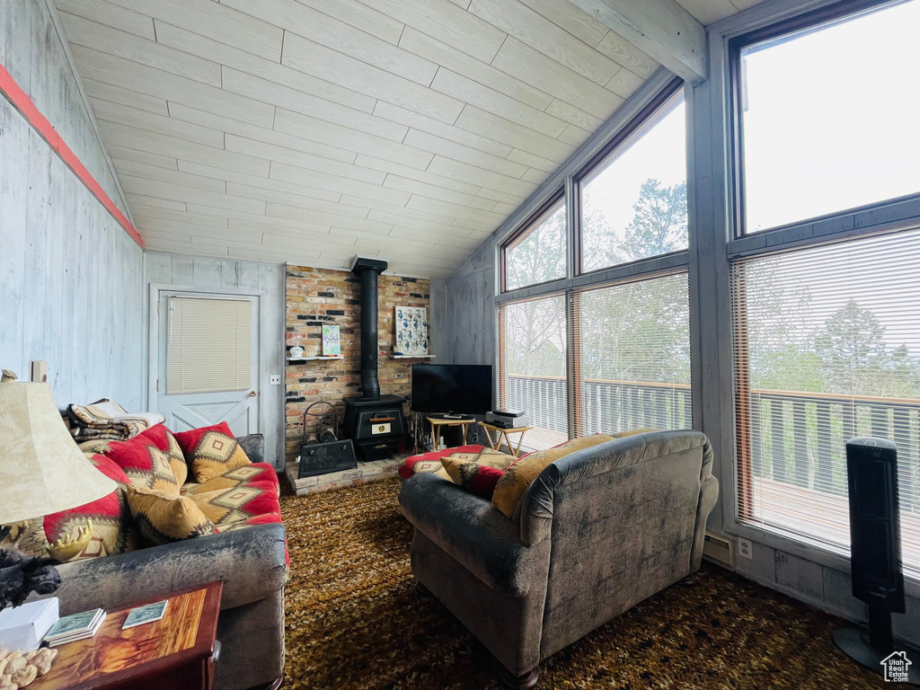 Living room with a wood stove and lofted ceiling with beams