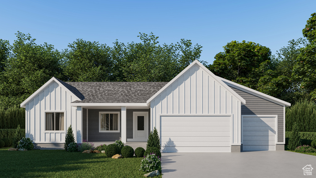 Modern farmhouse featuring a garage and a front yard