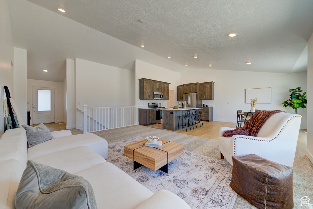 Living room featuring vaulted ceiling and light hardwood / wood-style floors