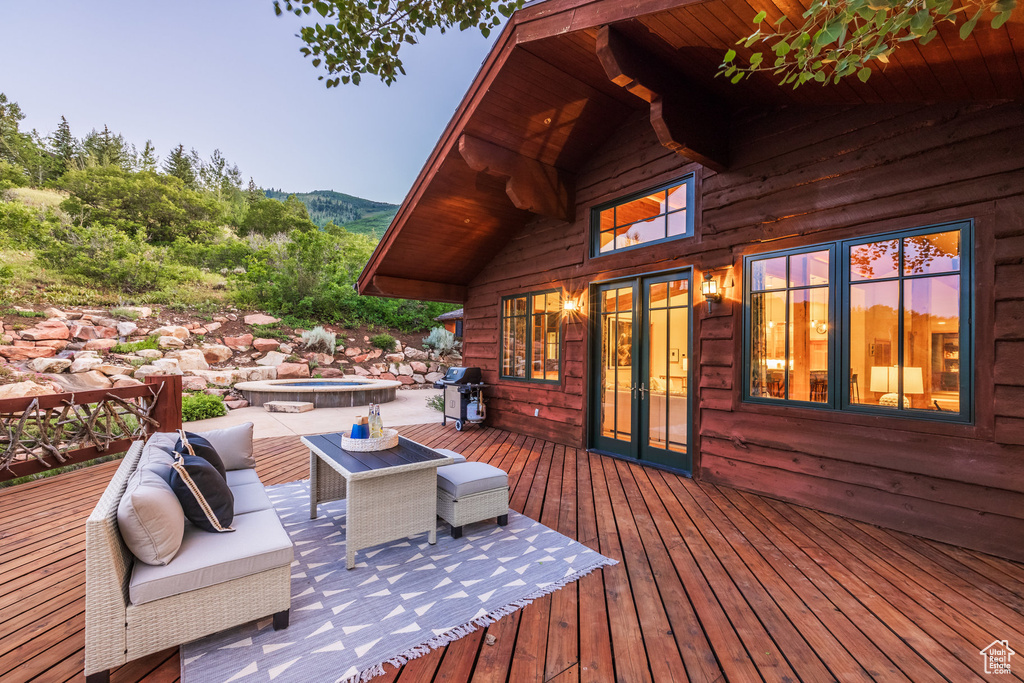 Wooden deck with an outdoor hot tub and french doors