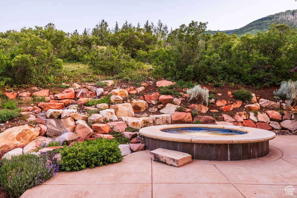 View of patio / terrace featuring a mountain view and a hot tub