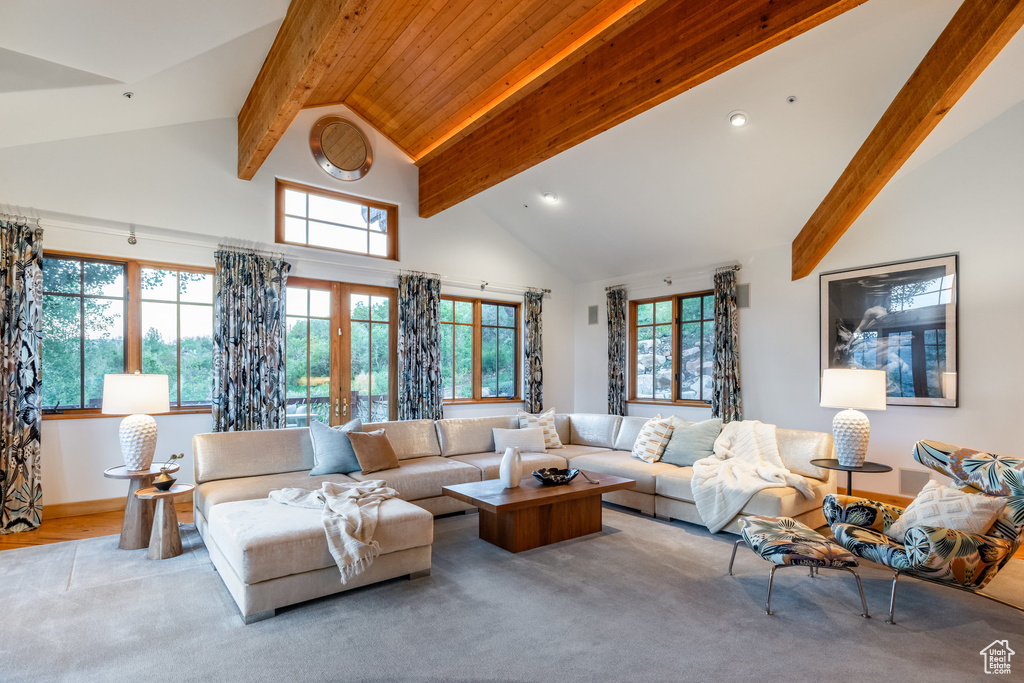 Carpeted living room featuring plenty of natural light, high vaulted ceiling, beamed ceiling, and french doors