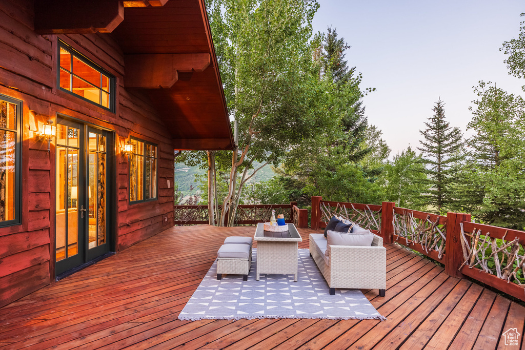 Wooden terrace featuring an outdoor hangout area and french doors