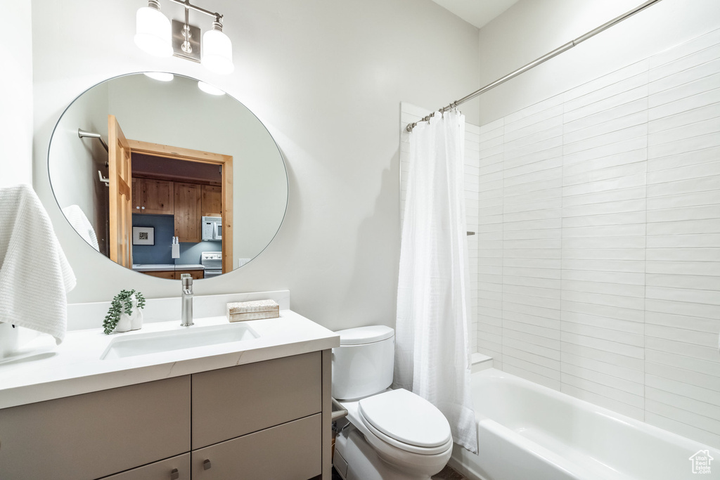 Full bathroom featuring shower / tub combo, toilet, and vanity