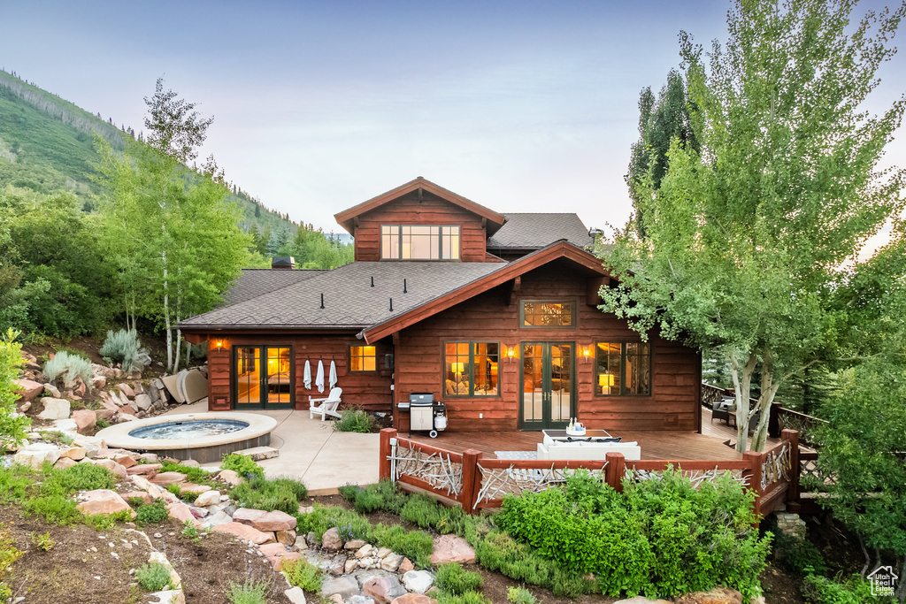 Back of property with a patio area, a deck, and french doors