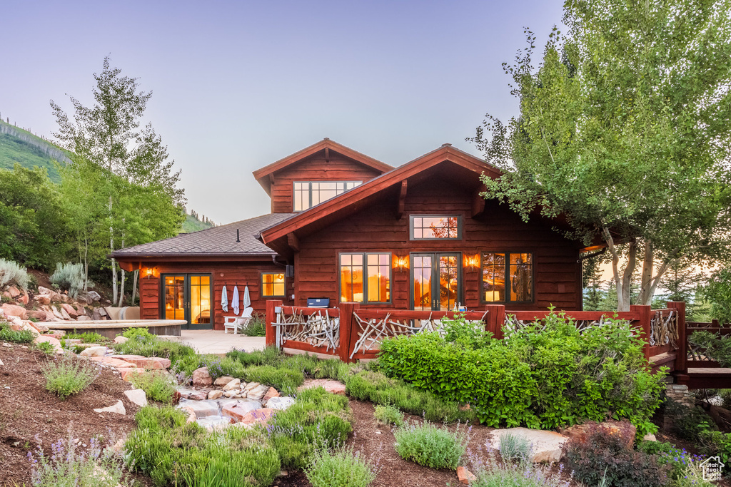 Back house at dusk with a wooden deck