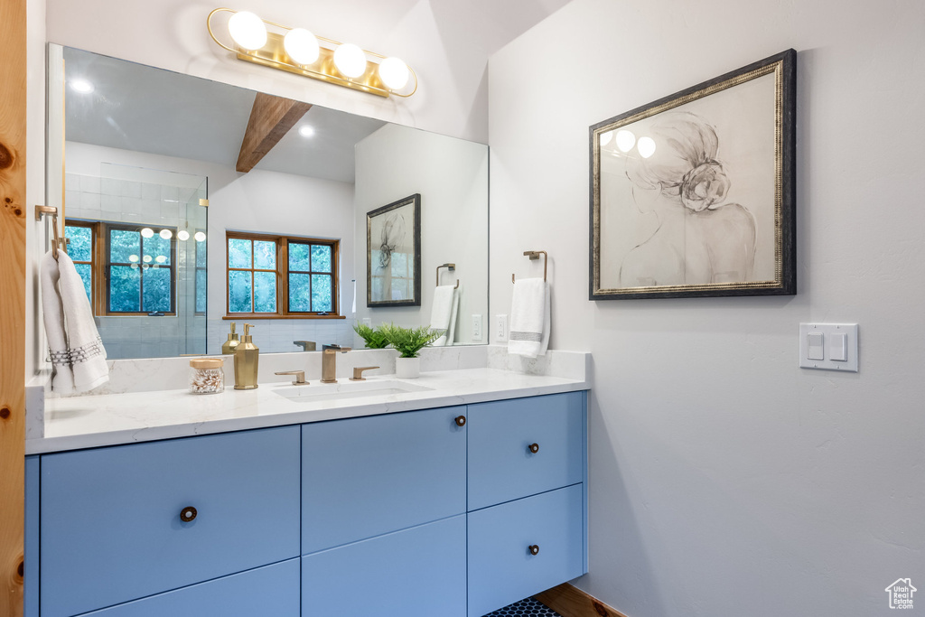 Bathroom featuring beam ceiling and vanity