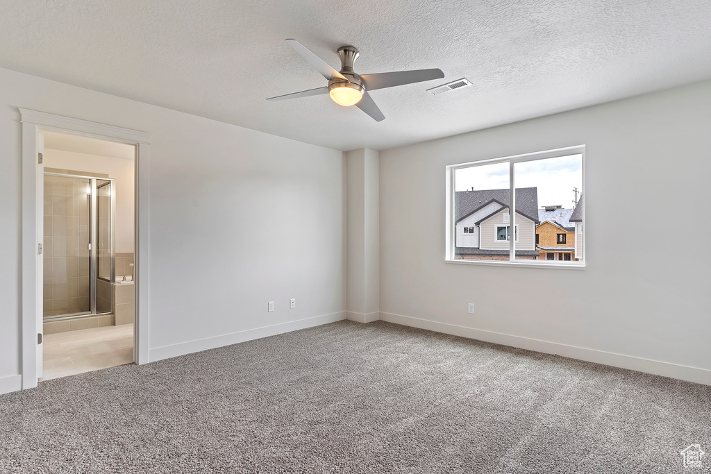 Spare room featuring a textured ceiling, ceiling fan, and carpet flooring