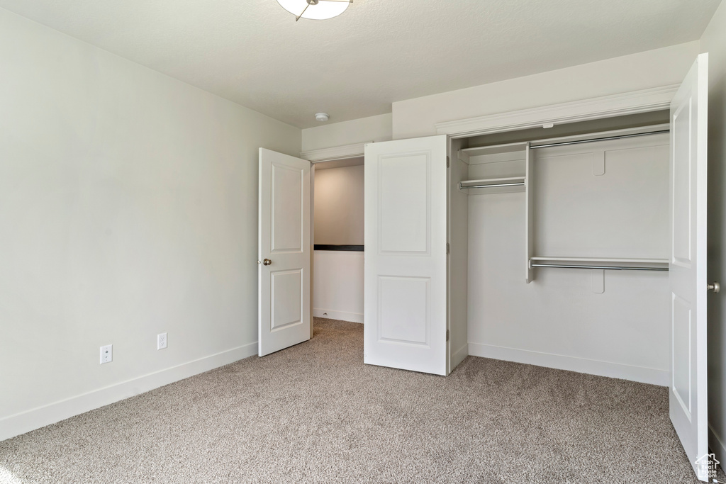 Unfurnished bedroom with a closet and light colored carpet