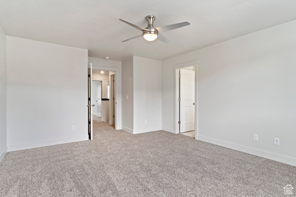 Unfurnished bedroom with ceiling fan and light colored carpet