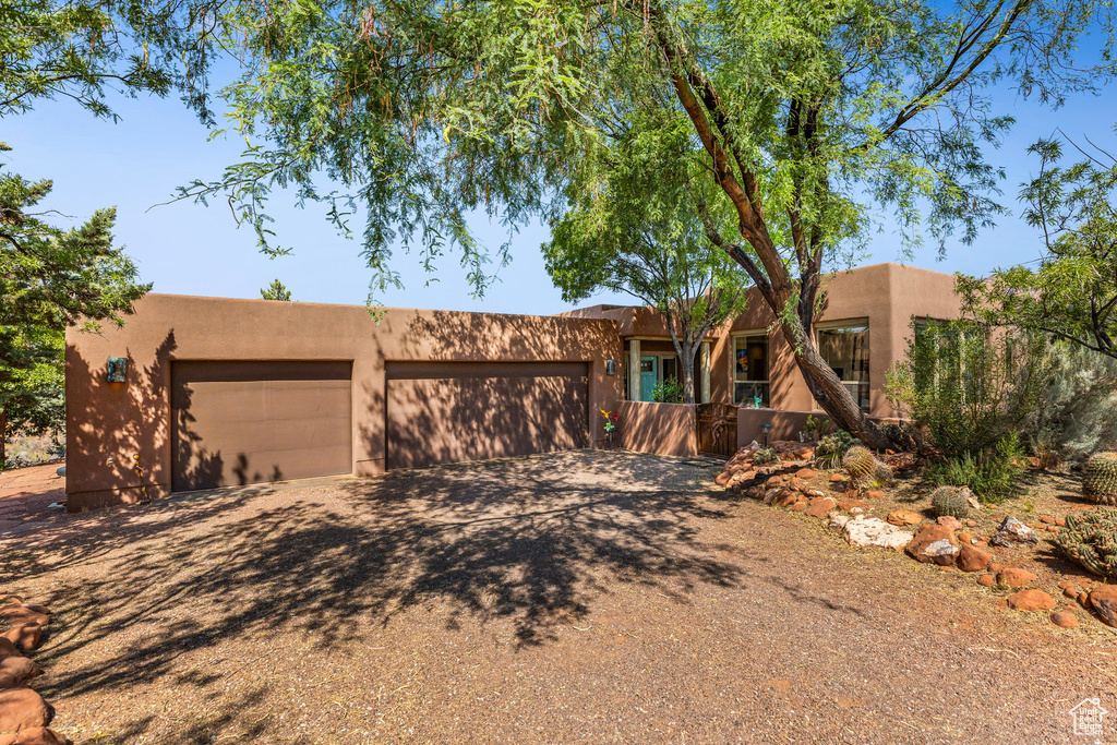 Pueblo revival-style home featuring a garage