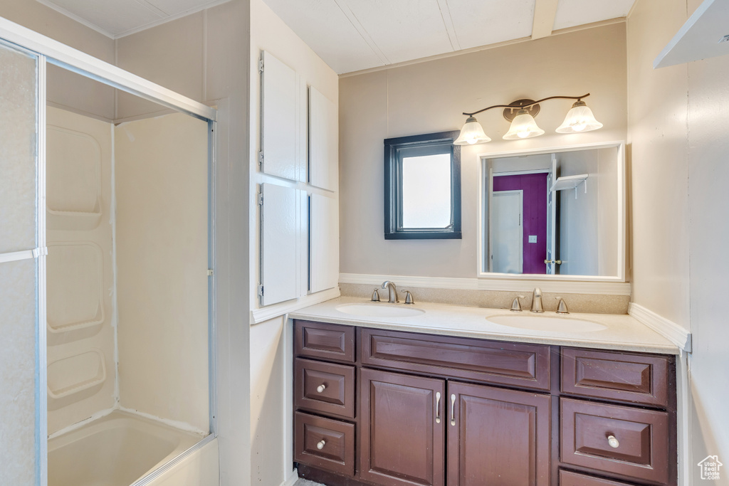 Bathroom with double vanity and enclosed tub / shower combo