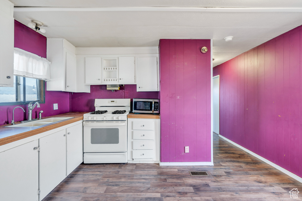 Kitchen with white cabinetry, wood-type flooring, white range with gas cooktop, and sink